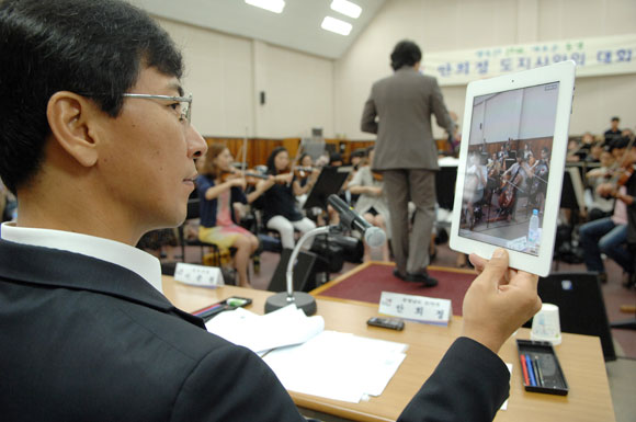안희정 지사가 17일 충남교향악단의 연주를 태블릿pc로 촬영하고 있다.