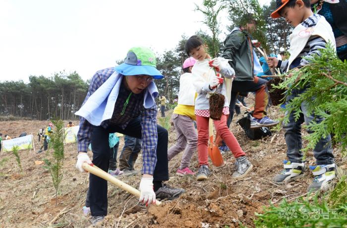 안희정 도지사가 식목일 나무심기 행사에서 아이들과 나무를 심고 있다.