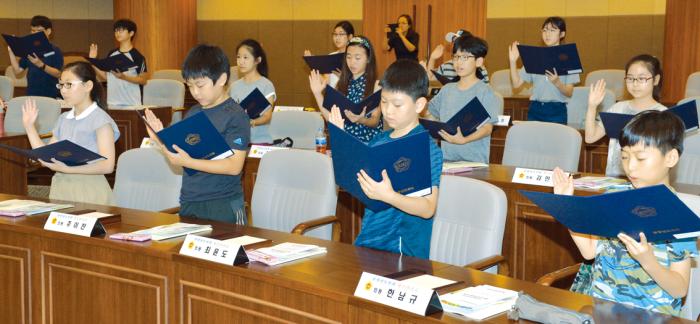 충남도의회 ‘청소년 의회 교실’에 참여한 천안불당초등학교 학생들이 본회의장에서 의원 선서를 하고 있다.